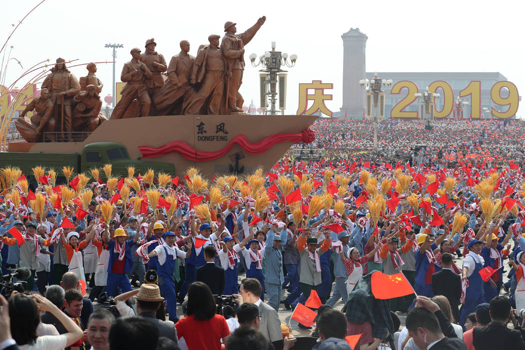 Participants march during the celebration to commemorate the 70th anniversary of the founding o ...