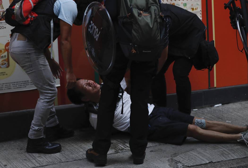 An injured anti-government protester is attended to by others during a clash with police in Hon ...