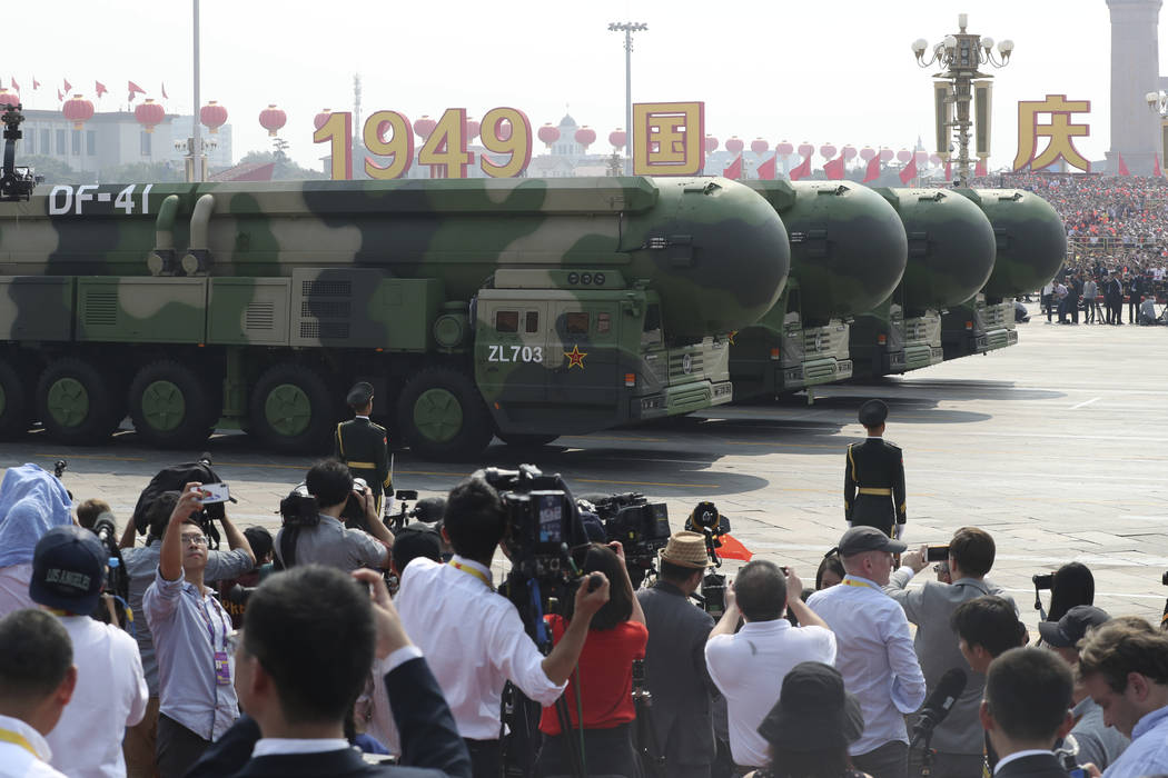 Military vehicles roll down as members of a Chinese military honor guard march during the parad ...