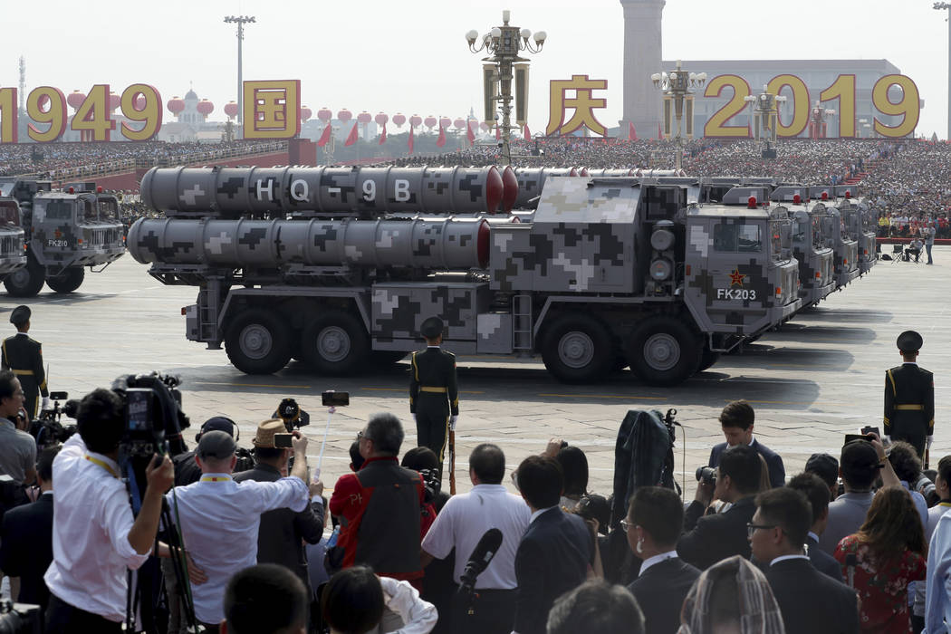 Military vehicles roll down as members of a Chinese military honor guard march during the parad ...