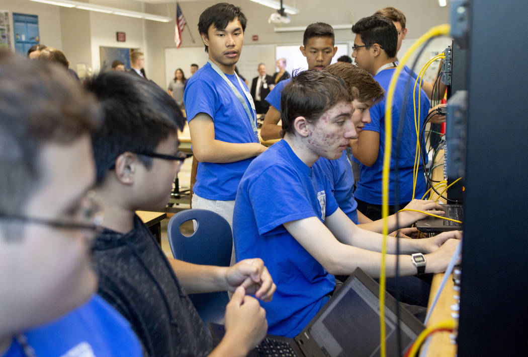 Computer science juniors work on a project in class during a tour to individuals representing ...