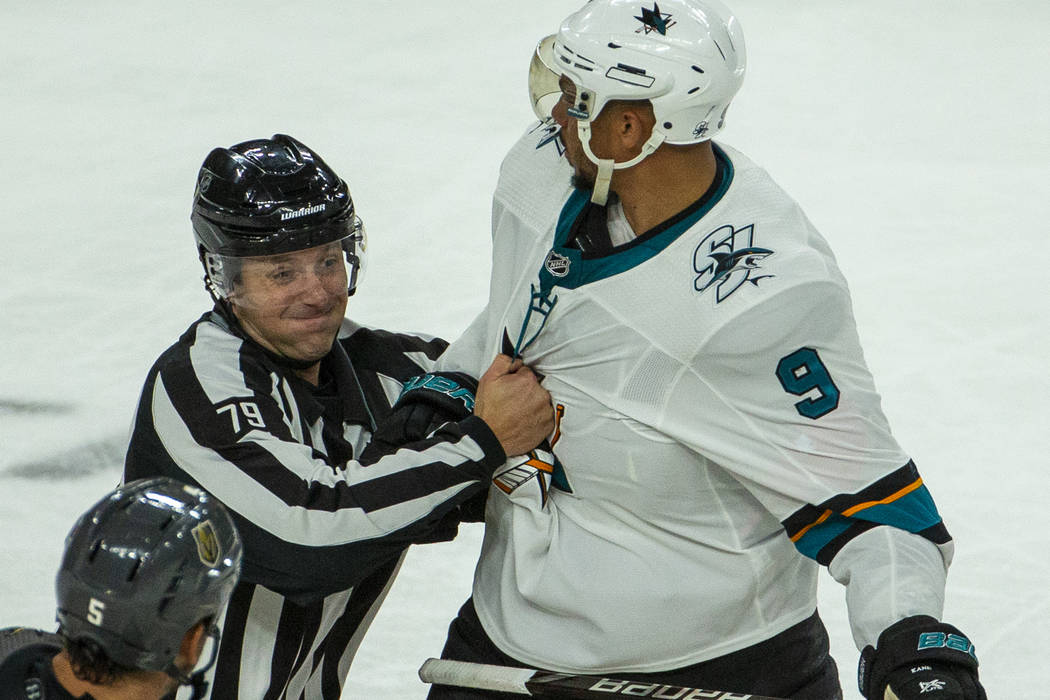 San Jose Sharks left wing Evander Kane (9) is grabbed by a referee after fighting with Vegas Go ...