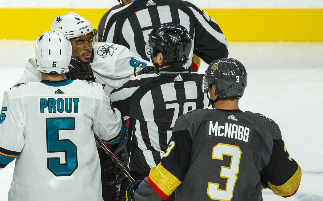 San Jose Sharks left wing Evander Kane (9, top left) struggles with a referee after fighting wi ...