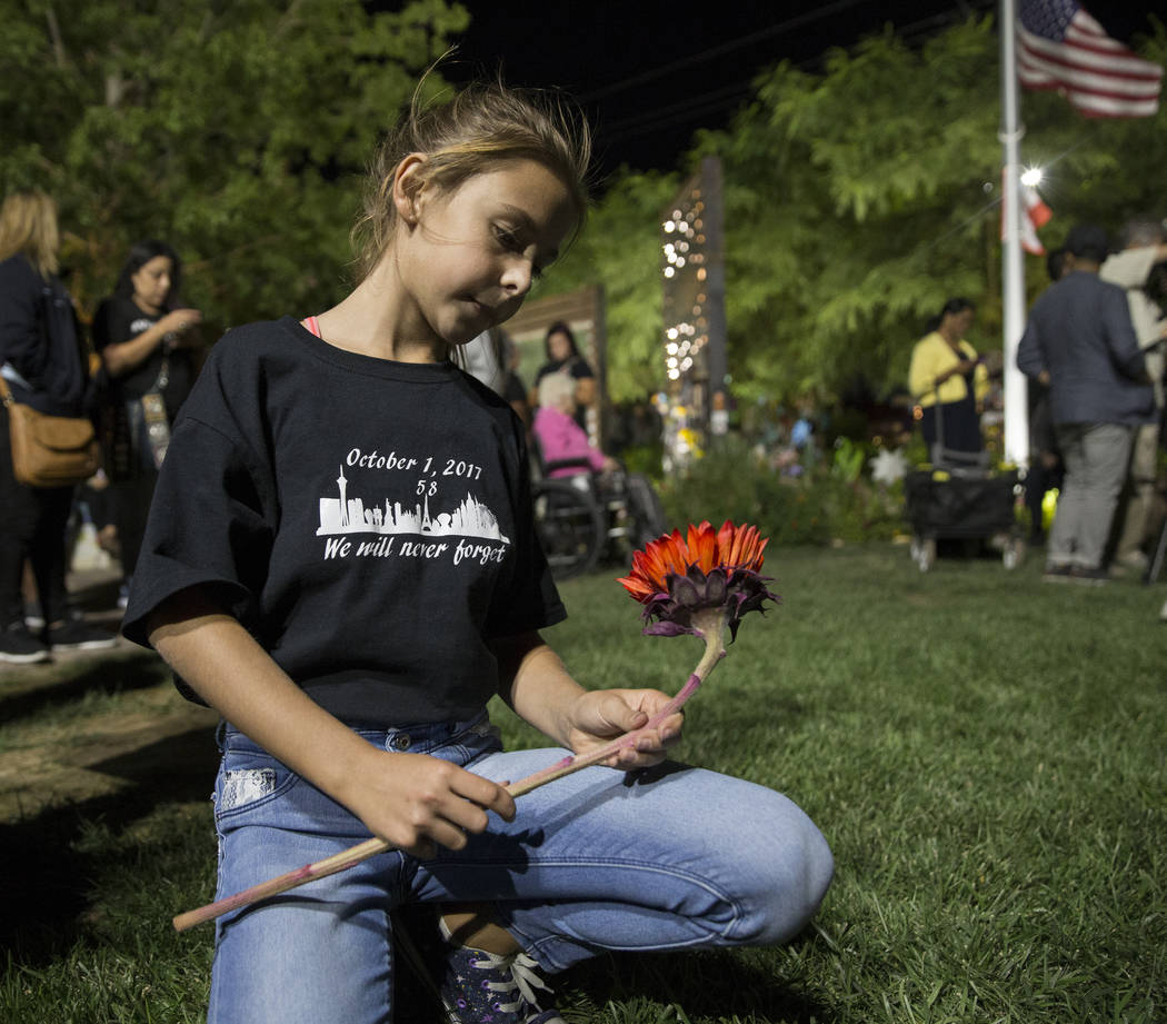 Ella Goldy holds a red sunflower honoring her mother Samantha Olander, who survived the Route 9 ...