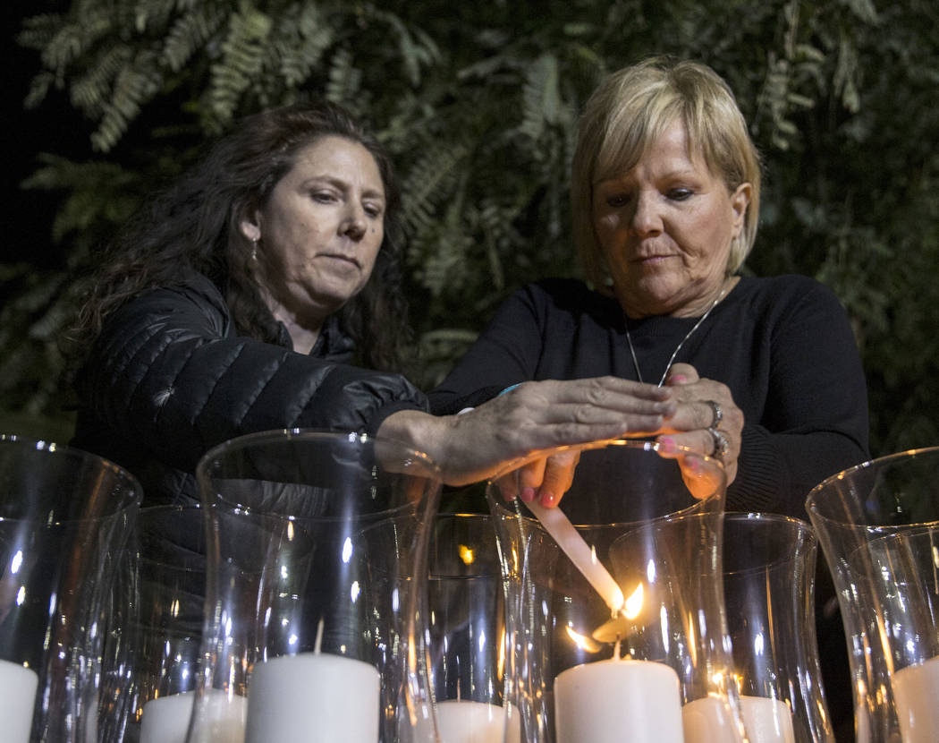 Mauricia Baca, left, and Esther Reinecke light candles honoring the 58 victims of the Route 91 ...