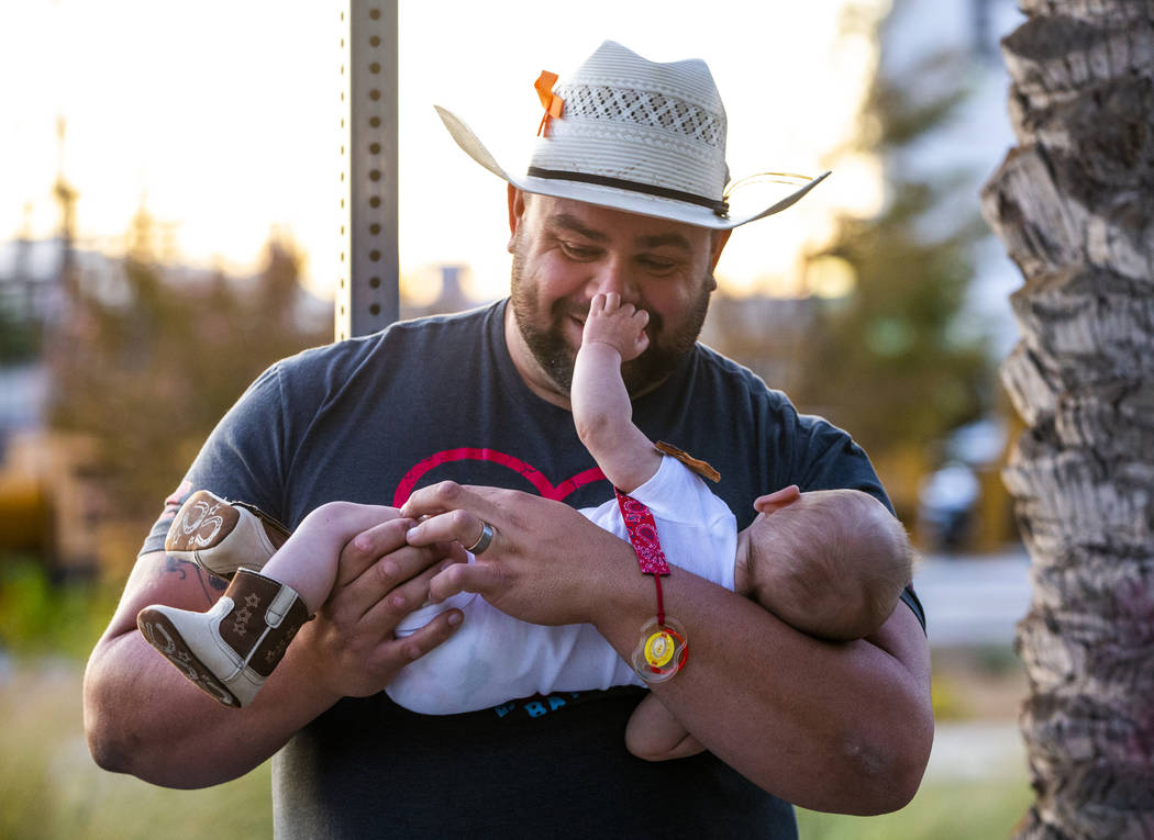 October 1st survivor Gerald Crisp plays with his son Colby, 4 month-old, while visiting the Las ...
