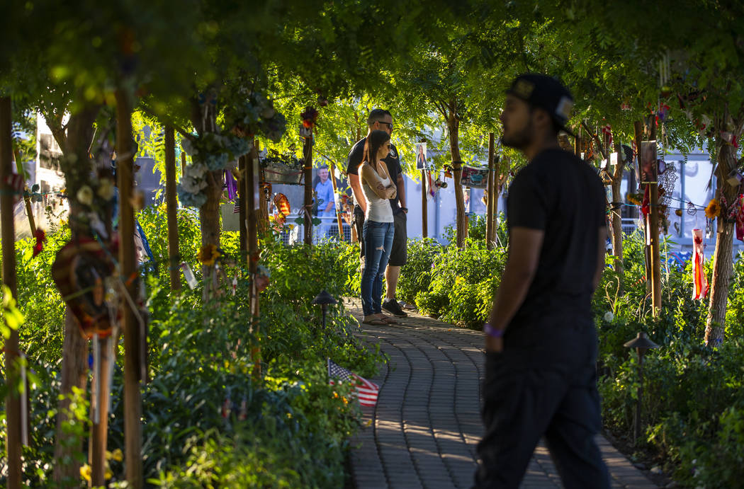 Visitors walk along the path of decorated trees at the Las Vegas Healing Garden on Tuesday, Oct ...