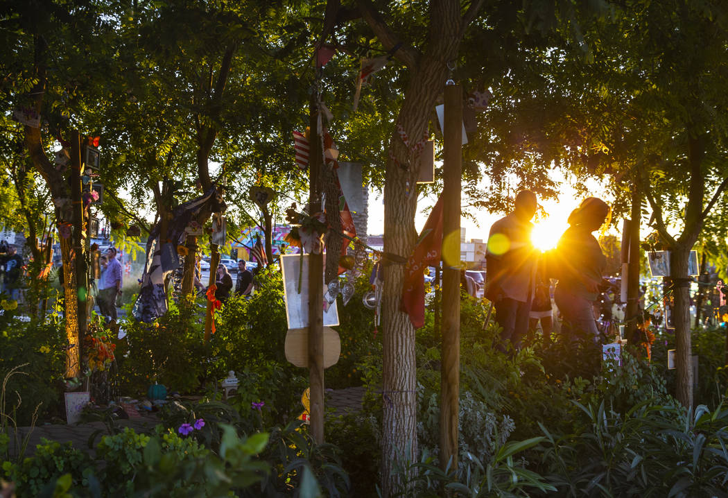 The sun begins to set as visitors walk along the path of decorated trees at the Las Vegas Heali ...