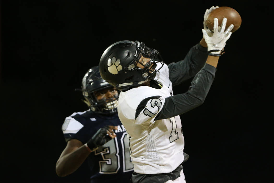 Palo Verde's Jahan Wright (13) makes a catch under pressure from Shadow Ridge's Dural Faust (30 ...