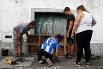 Residents board up a door in preparation for the arrival of hurricane Lorenzo in Horta, the cap ...