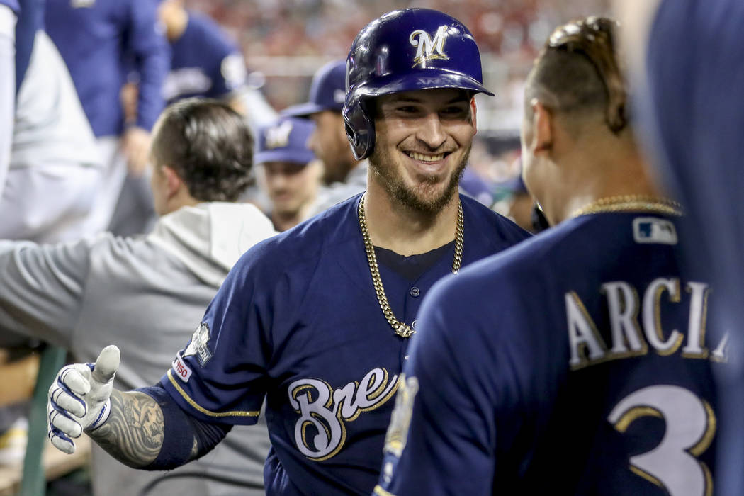 Milwaukee Brewers' Yasmani Grandal, center, celebrates with teammate Orlando Arcia (3) after hi ...