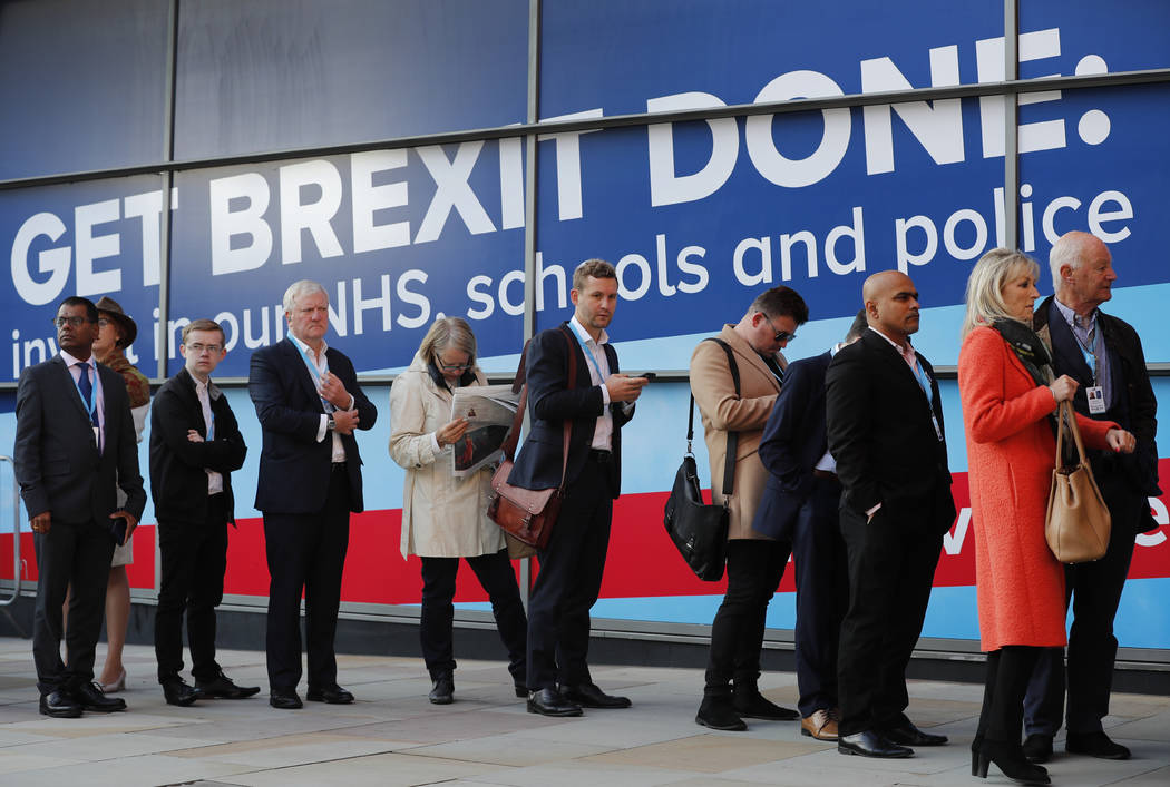 People queue to enter Manchester Central Convention Centre, where Britain's Prime Minister Bori ...