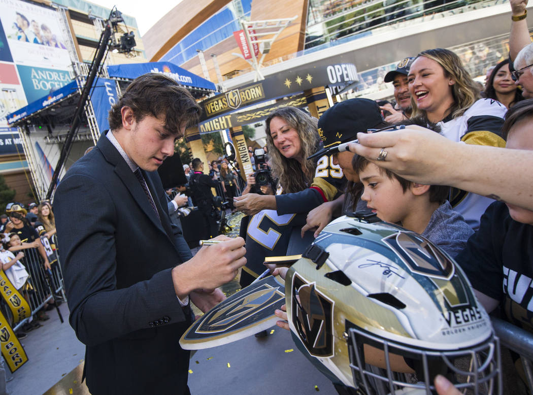 Golden Knights' Cody Glass signs autographs on the gold carpet after arriving for the NHL seaso ...