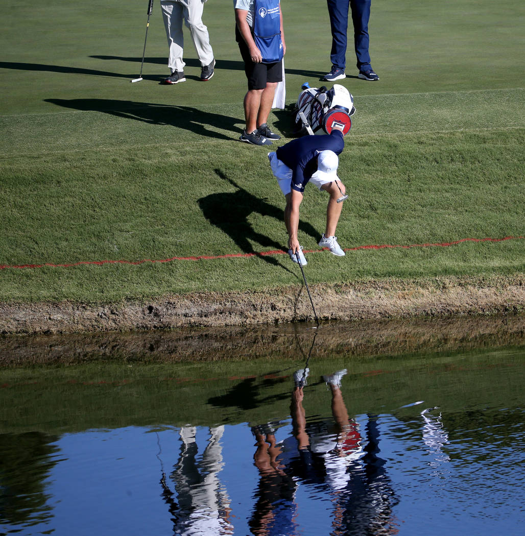 Bryson DeChambeau retrieves a partner's ball on the 18th green during the Shriners Hospitals fo ...