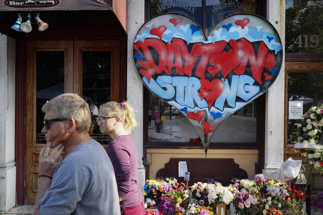 FILE - In this Aug. 7, 2019 file photo, pedestrians pass a makeshift memorial for the slain and ...