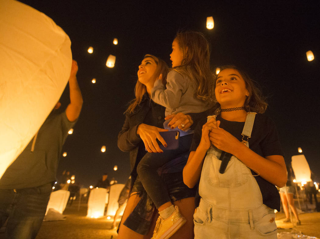 Jessica, June and Jade Laos watch their lanterns fly into the sky during the RiSE Lantern Festi ...