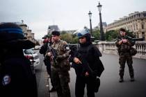 Armed police officers and soldiers patrol after an incident at the police headquarters after in ...