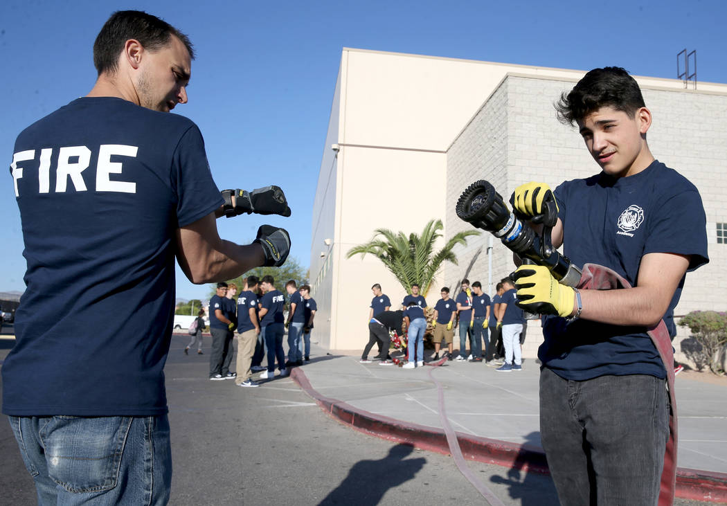Bonanza High School Fire Science Academy teacher Chris Batterman shows junior Enrique Flores ho ...