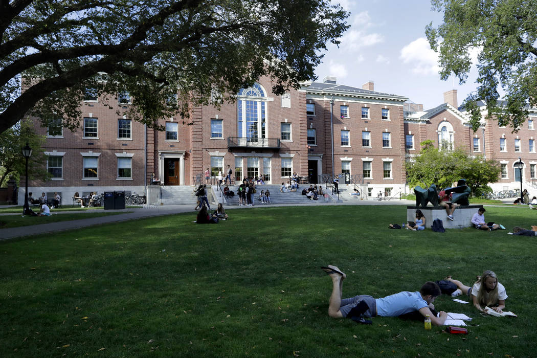 In this Sept. 25, 2019, photo, people rest on grass while reading at Brown University in Provid ...