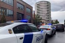 Police respond to a shooting at an apartment building, top rear, in Vancouver, Wash., Thursday, ...