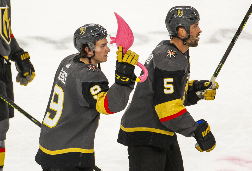 Vegas Golden Knights center Cody Glass (9) receives a pink flamingo and skates with teammate de ...