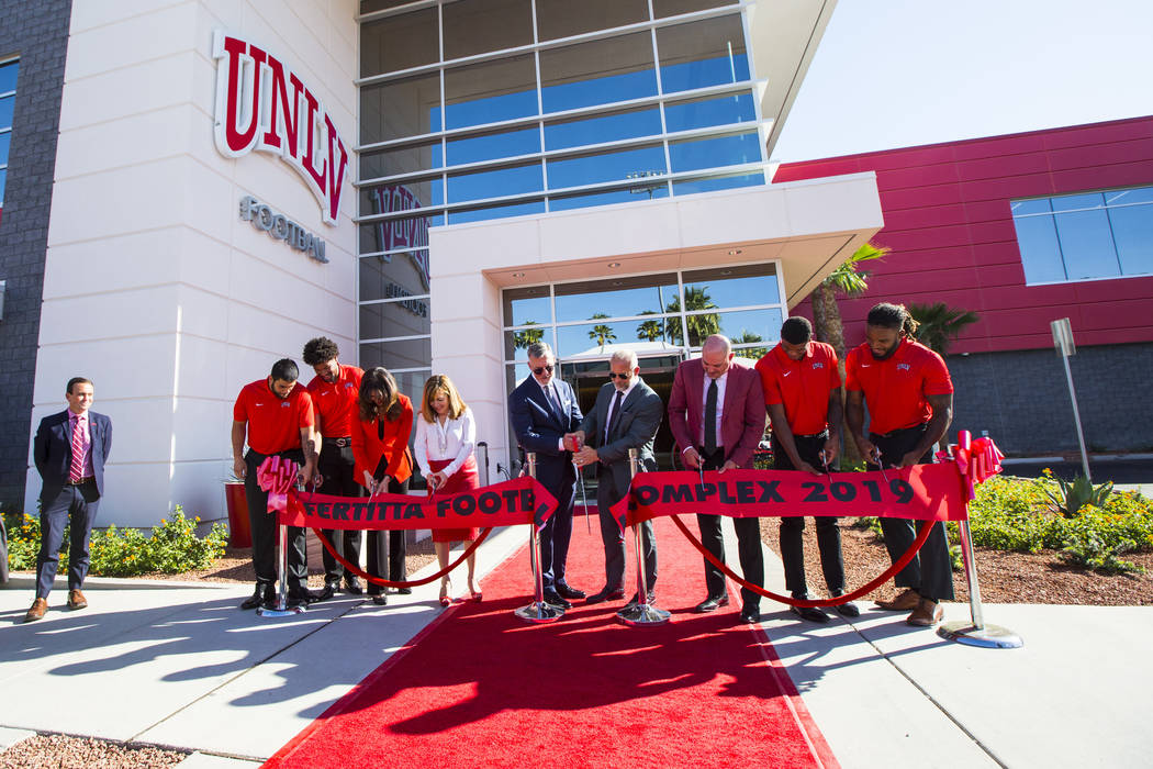 Frank Fertitta III, center left, and Lorenzo Fertitta, center right, are joined by UNLV footbal ...