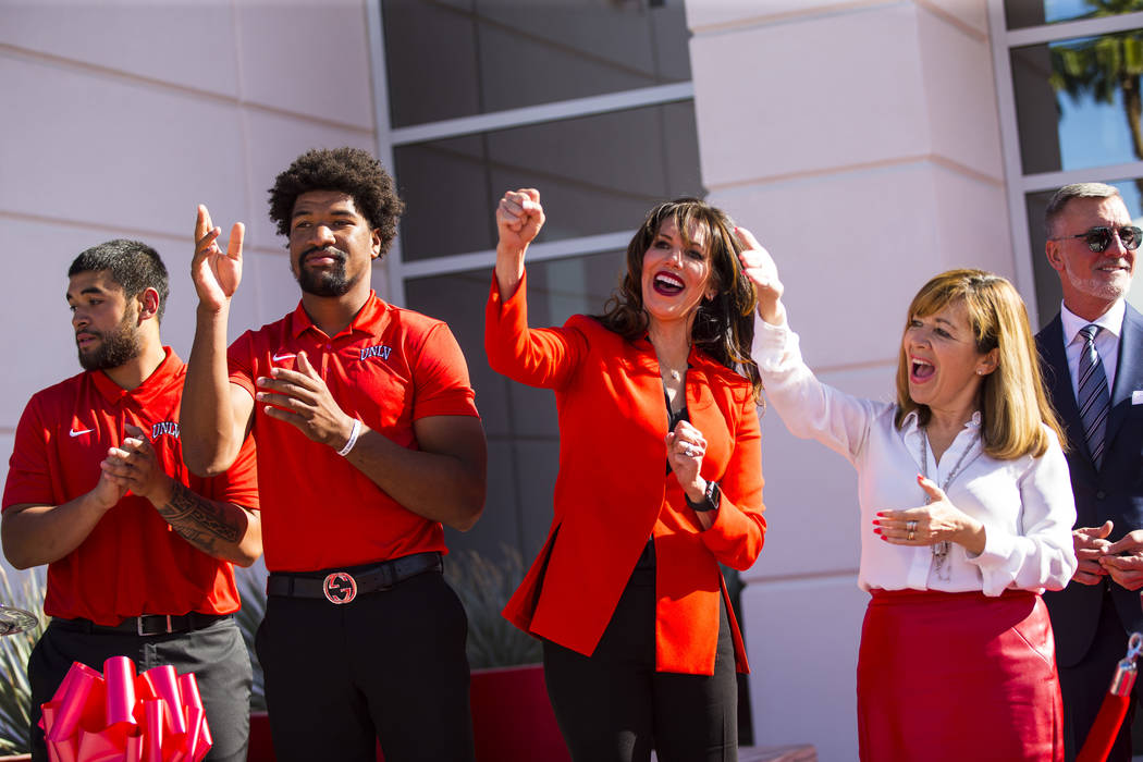 UNLV football players, from left, Giovanni Fauolo, and Armani Rogers cheer alongside UNLV athle ...