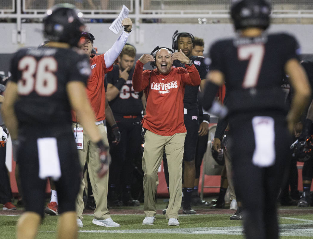 UNLV head coach Tony Sanchez sends in signals to his team in the second half during the Rebels ...