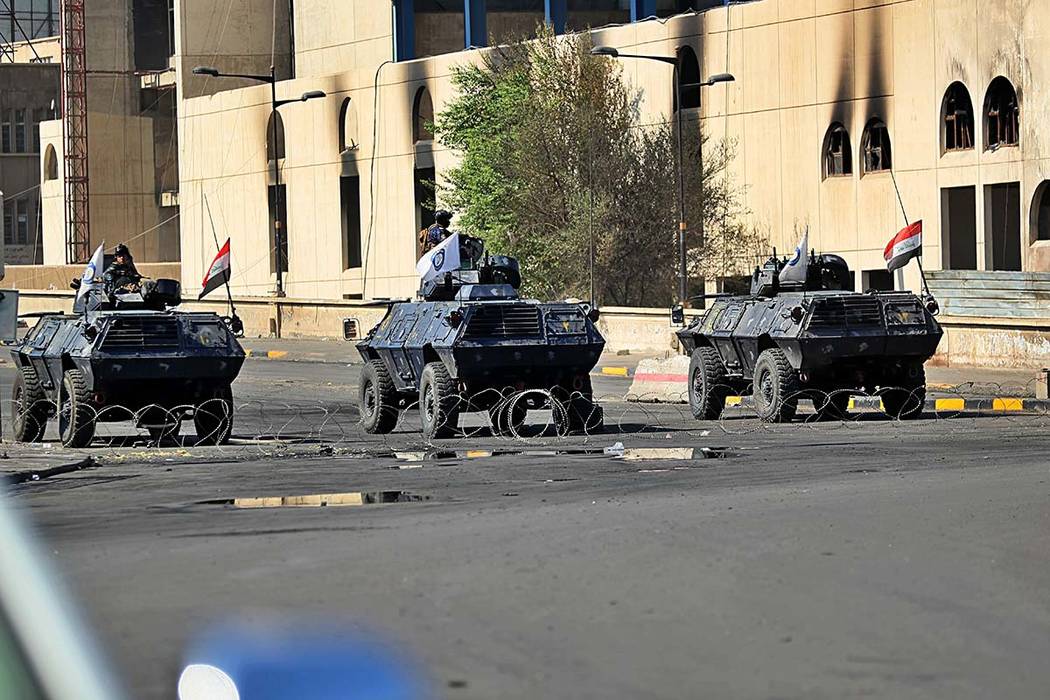 Iraqi security forces close a bridge road near the site of the protests in Tahrir square, centr ...