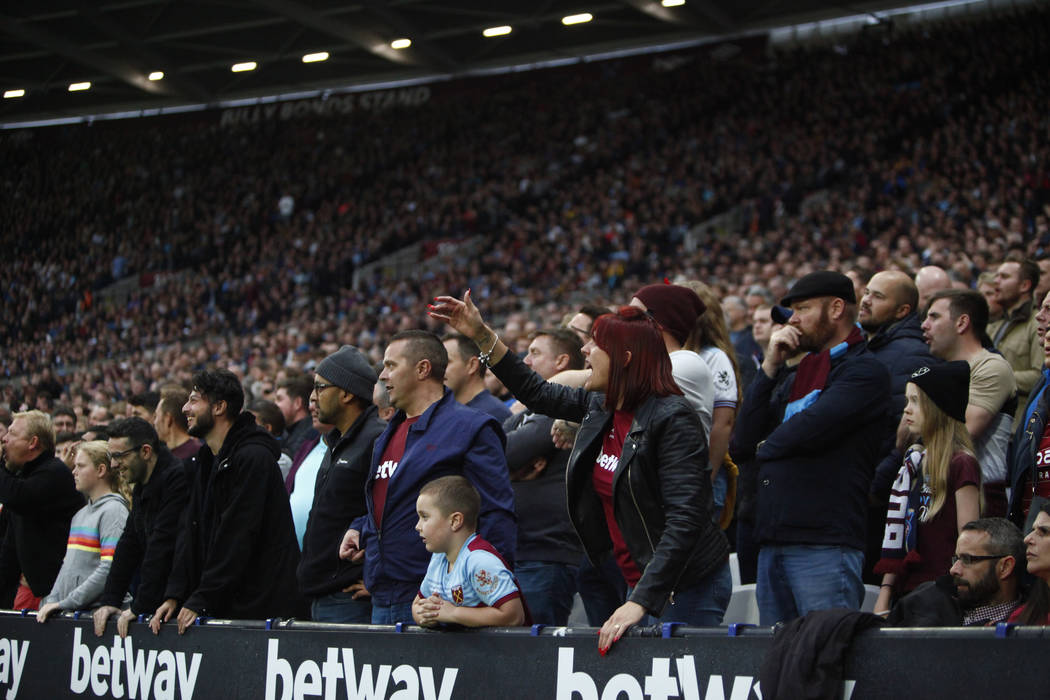 Fans react to a play during the first half of an English Premier League soccer match between th ...