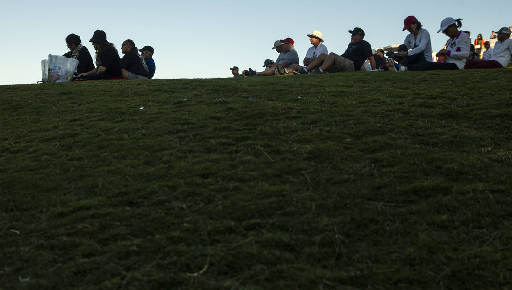 Gallery members sit in the setting sunlight about hole 18 during the third round of Shriners Ho ...