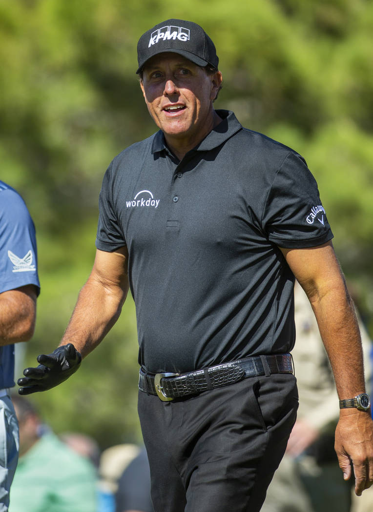 Phil Mickelson smiles at some fans as he walks up the fairway on hole 1 during the third round ...