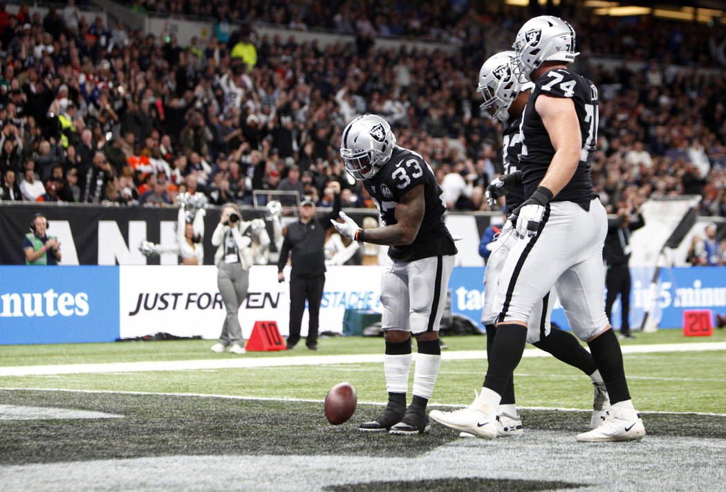 Oakland Raiders running back DeAndre Washington (33) bows after scoring a touchdown as tight en ...