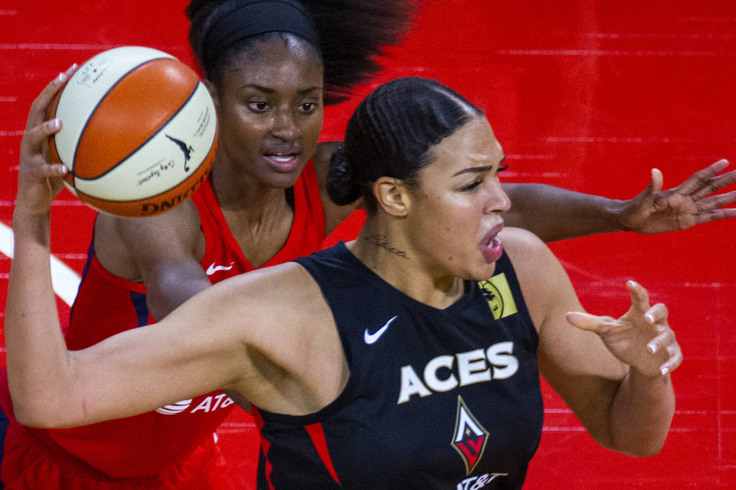 Las Vegas Aces center Liz Cambage (8, front) looks for a pass over Washington Mystics forward L ...