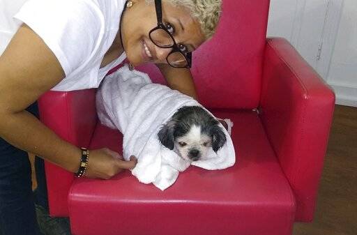 In this Tuesday, Oct. 1, 2019 photo provided by Altagracia Baldera, Baldera poses with her dog ...