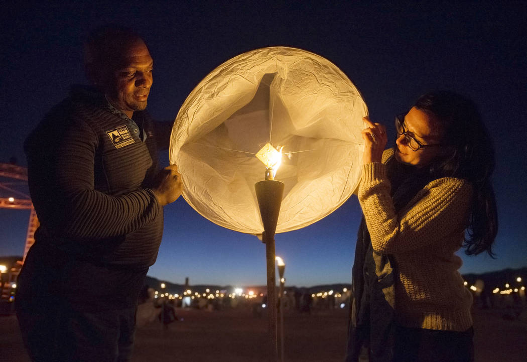 Mike Bryant, left, and Katie Chavez hold their lantern over a flame during the RiSE festival on ...