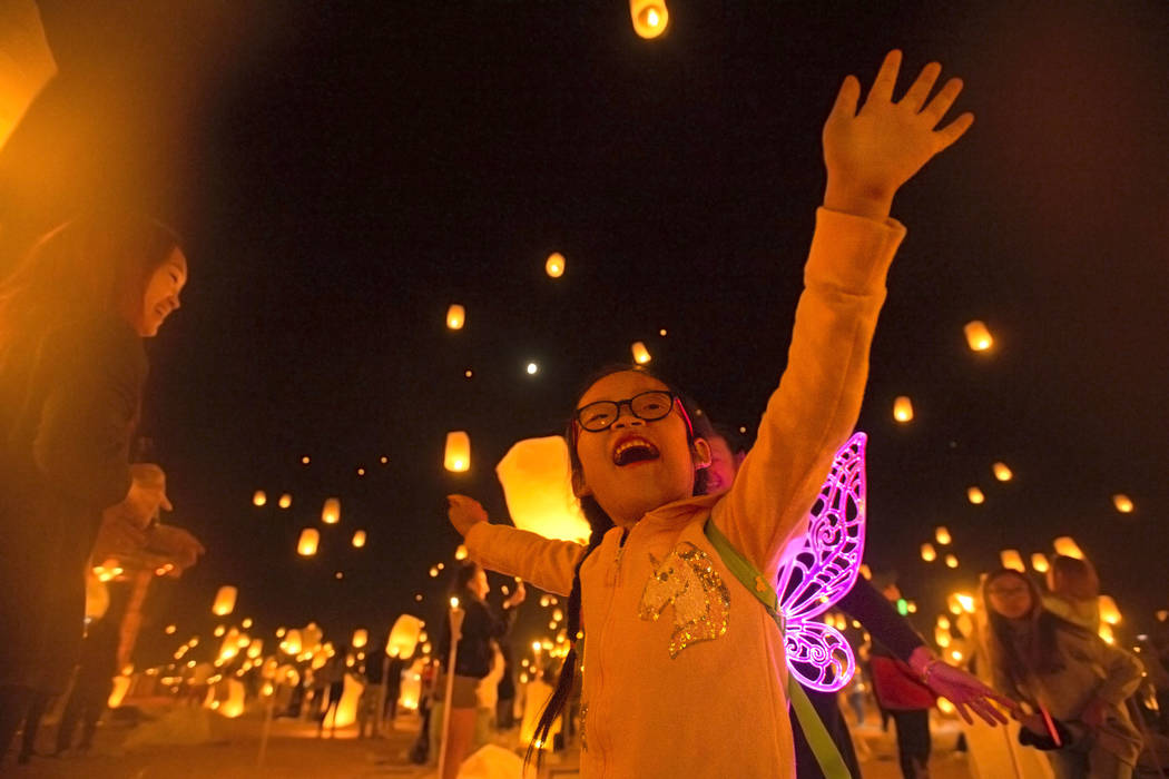 Keira Wang, 5, from Rosemead, Calif., watches lanterns be released during the RiSE festival on ...