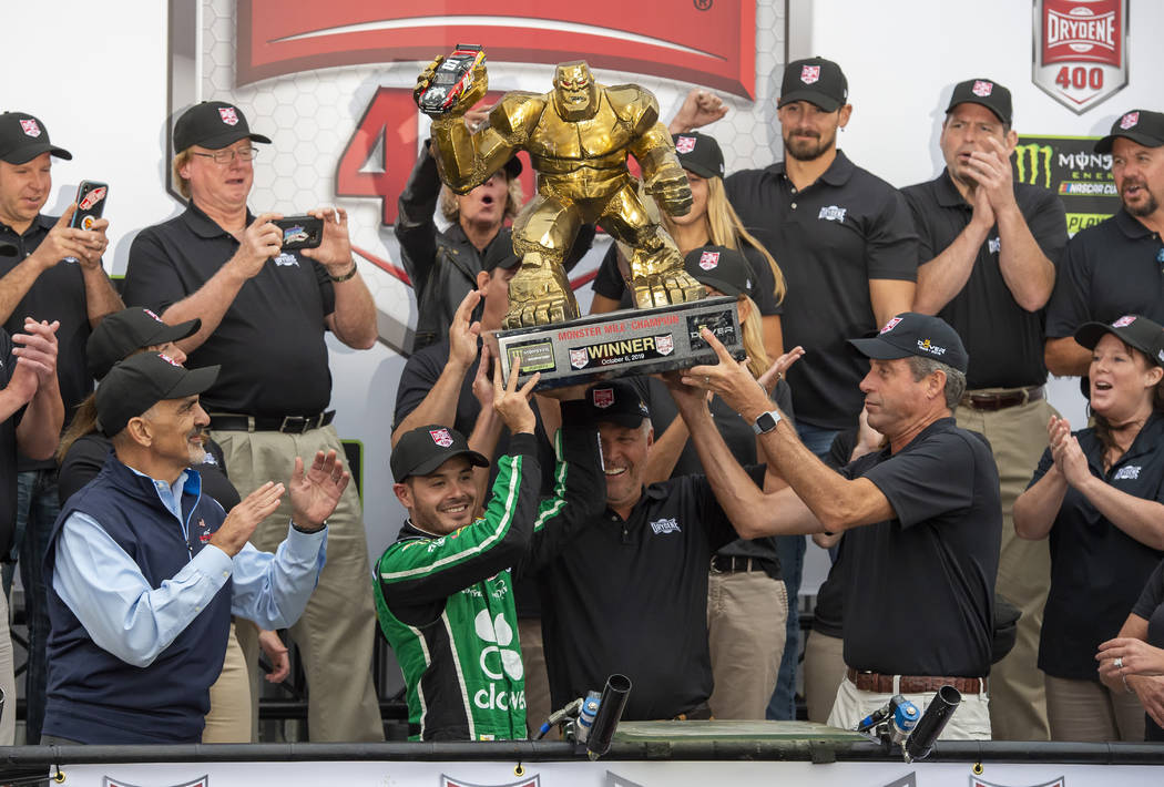 Kyle Larson, front left center, gets help in holding up the trophy after his win in the NASCAR ...