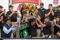 Kyle Larson, front left center, gets help in holding up the trophy after his win in the NASCAR ...