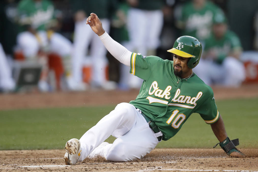 Oakland Athletics' Marcus Semien (10) scores against the Tampa Bay Rays during the third inning ...