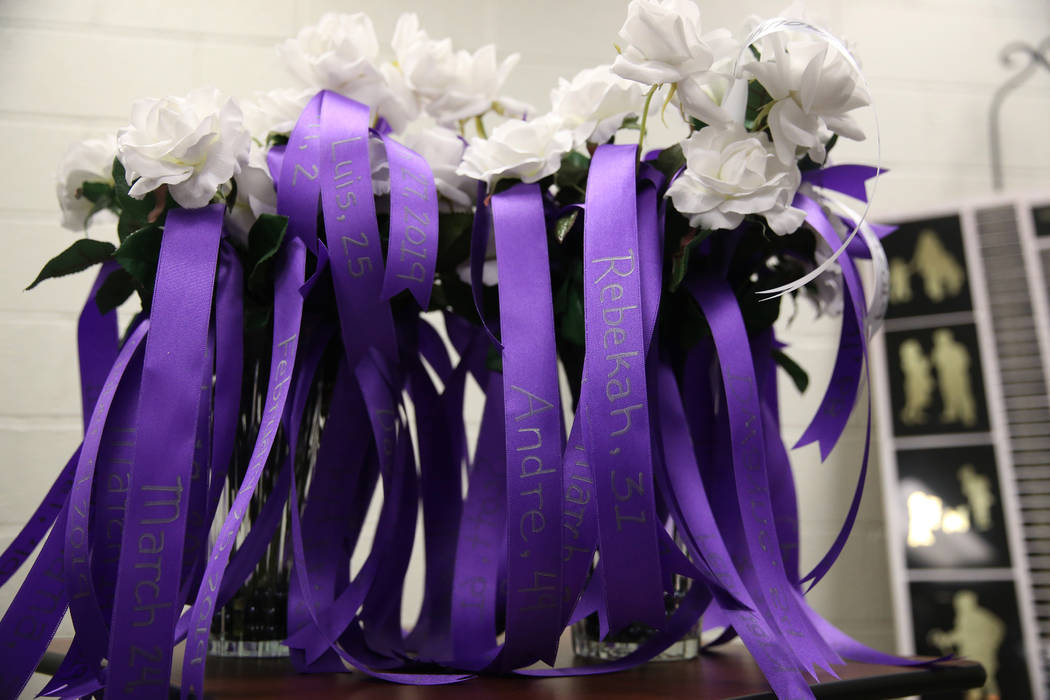 Flowers with the names of domestic violence victims are displayed during a domestic violence me ...