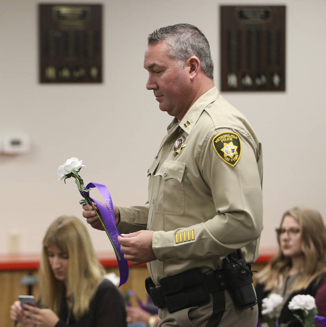 Las Vegas Metropolitan Police Department Capt. Sean Toman presents a flower with a name of a do ...