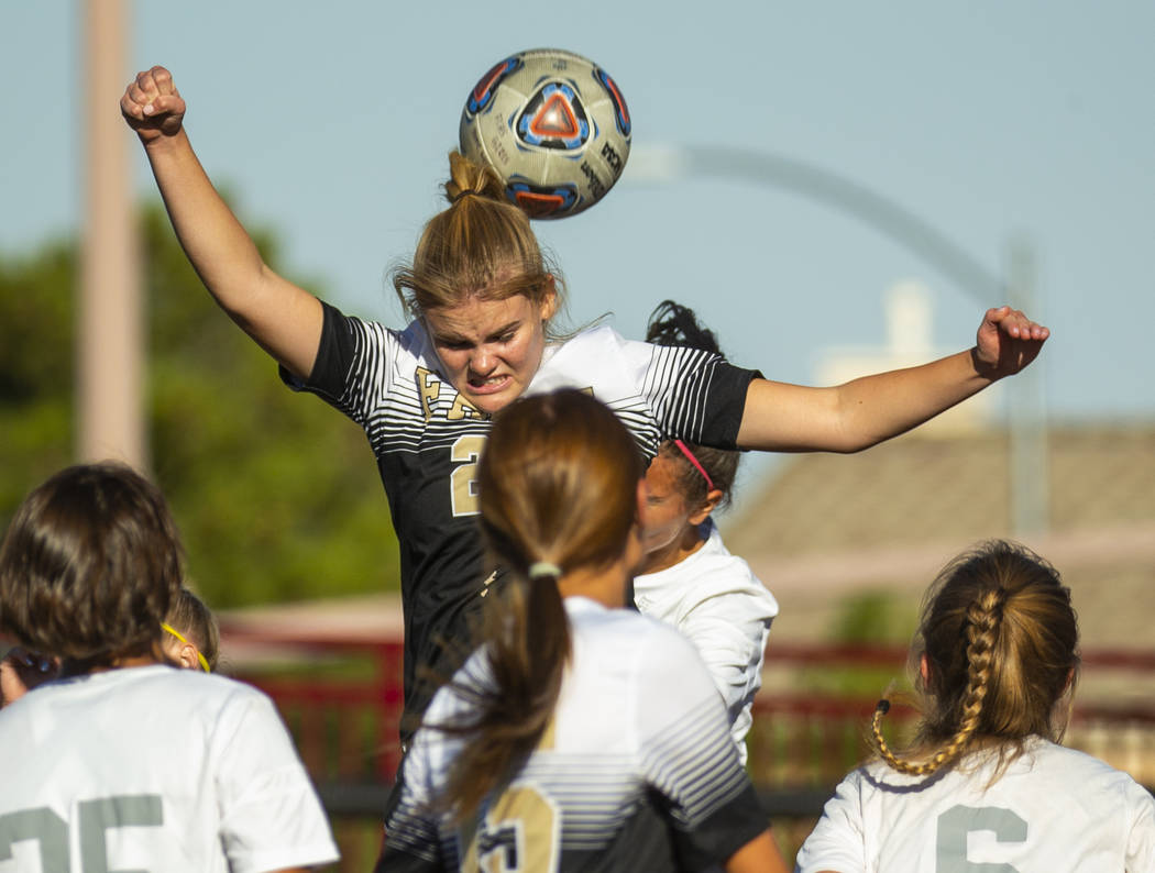 Faith Lutheran's Amelia McManus (20) heads the ball away from Arbor View defenders during the f ...