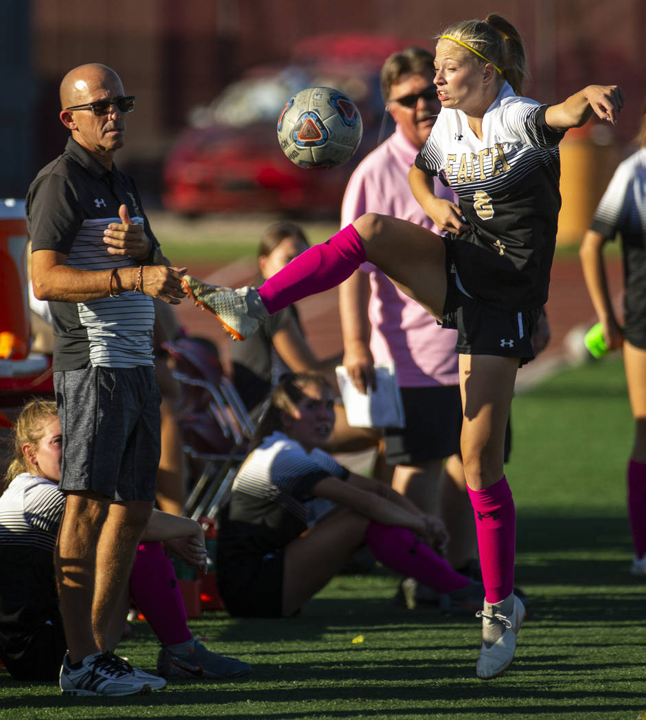 Faith Lutheran's Mackenzie Folk (8) attempts to save the ball with a kick on the sidelines vers ...