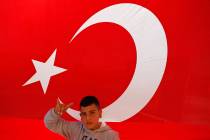 A youth flashes a hand gesture representing the Turkish far-right gray wolves organisation as h ...