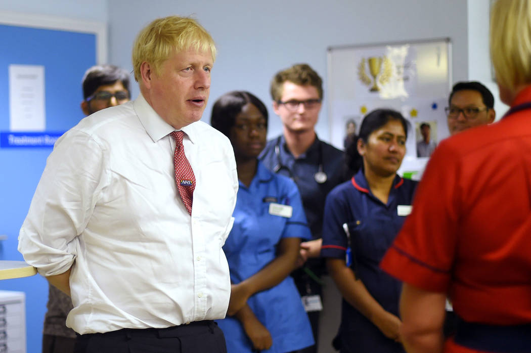Britain's Prime Minister Boris Johnson speaks to mental health professionals during his visit t ...