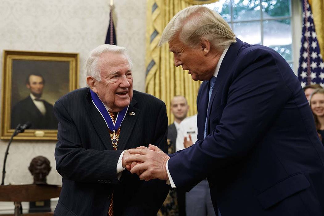 President Donald Trump shakes hands with former Attorney General Edwin Meese after presenting h ...