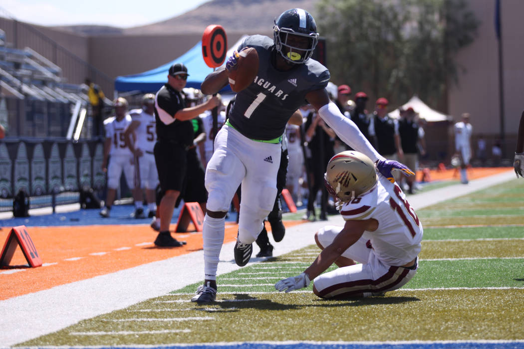 Desert Pines' Darnell Washington (1) scores a touchdown against Logan's Jaelin Hoth (16) during ...