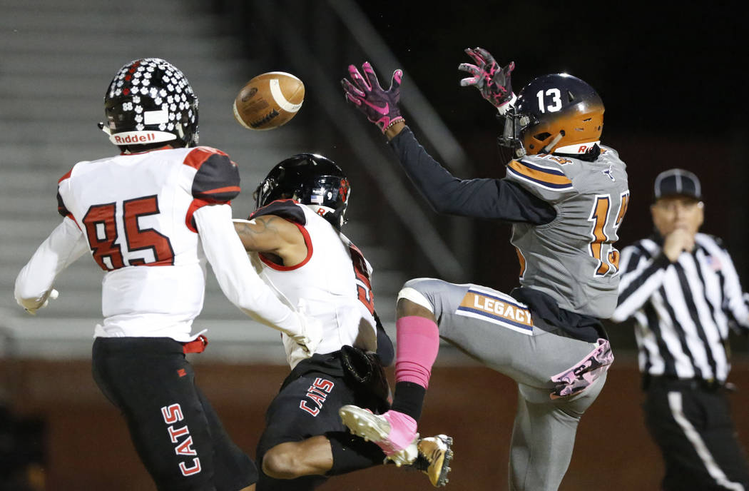 Legacy's Aaron Holloway (13) cannot catch a pass as Las Vegas' Christian Flores (85) and Devyn ...
