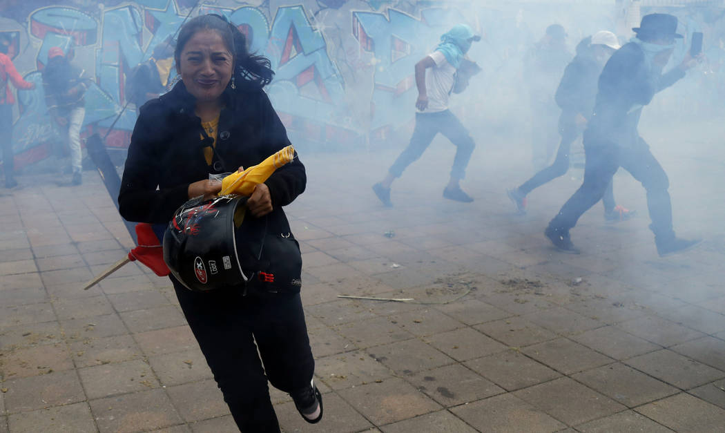 Anti-government protesters clash with police near the National Assembly in Quito, Ecuador, Tues ...
